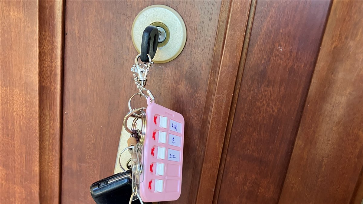 玄関ドアの鍵に付けた100均チェックホルダーで鍵の閉め忘れ防止を実践する様子