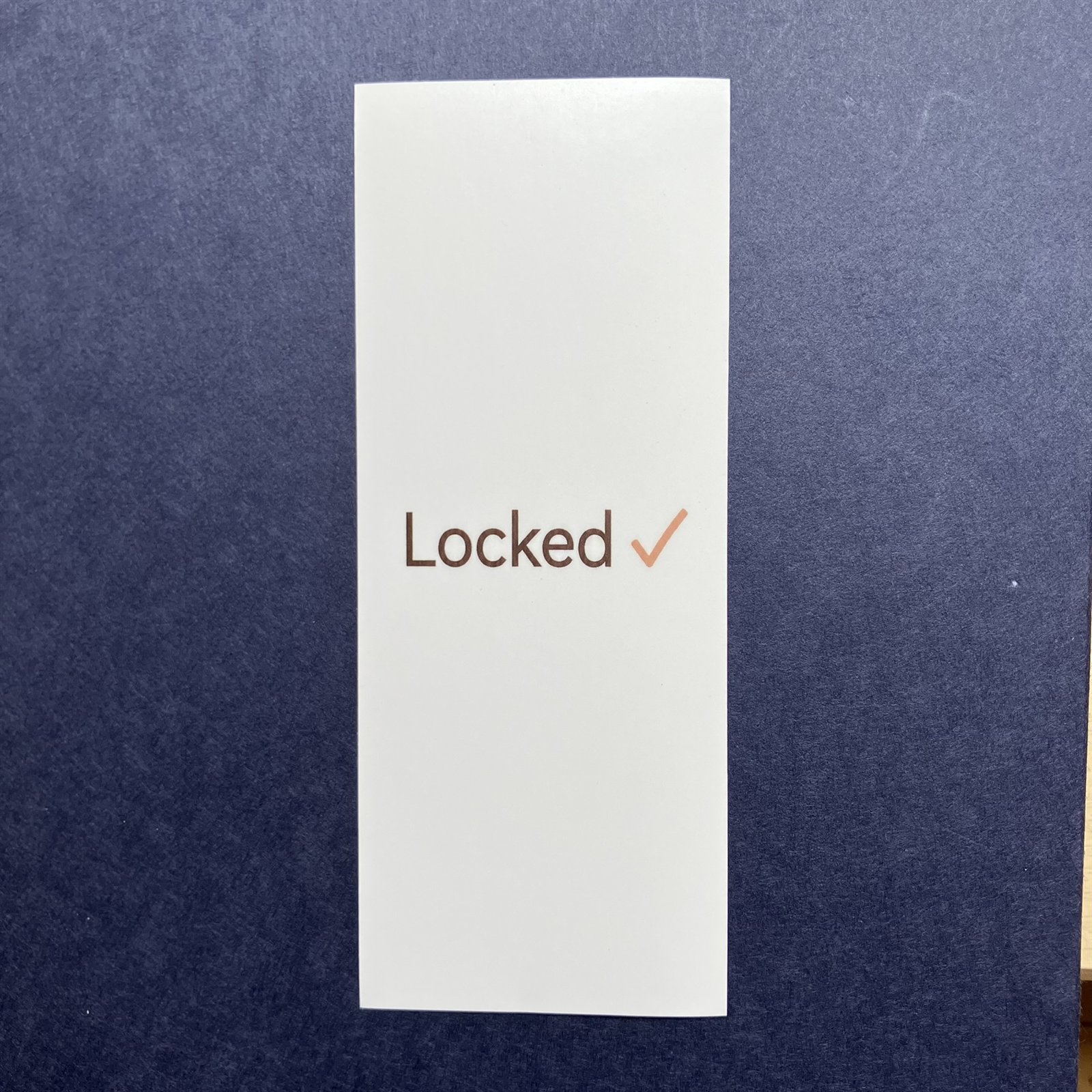 Locked 施錠確認ステッカーを紺色の台に立てかけたメイン写真